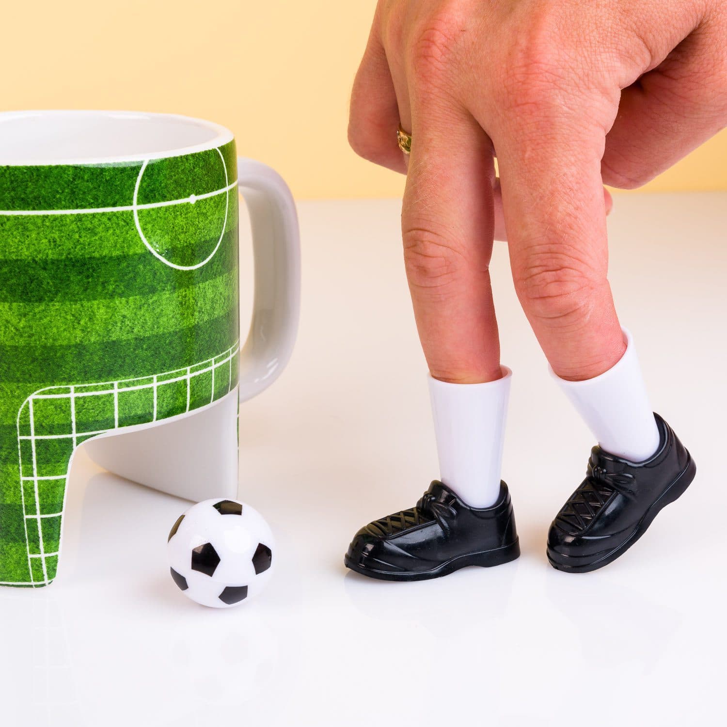 Fußballbecher mit Schuhen und Ball