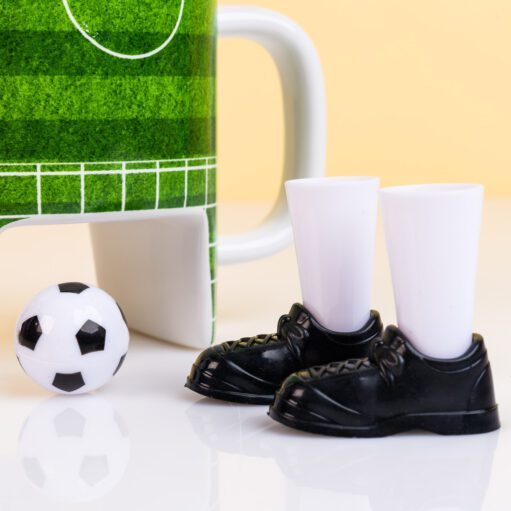Fußballbecher mit Schuhen und Ball